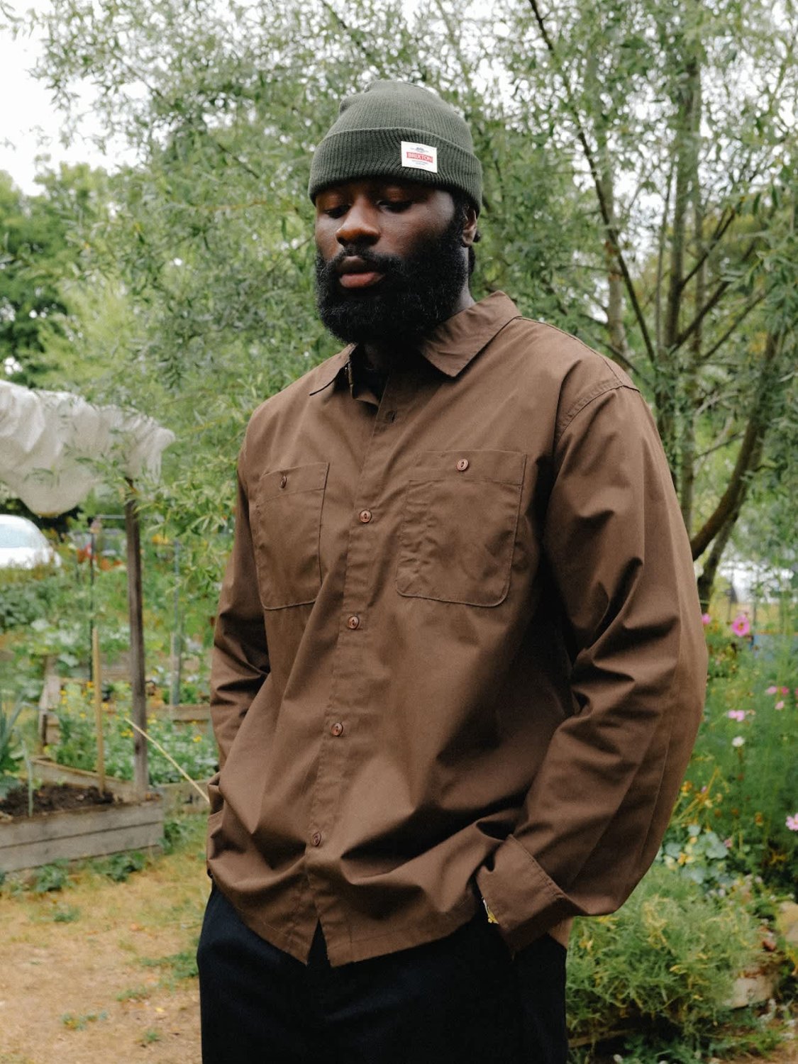 BRIXTON TRADEMARK BEANIE NAVY OVERHEAD MODEL WEARING BEANIE IN GARDEN
