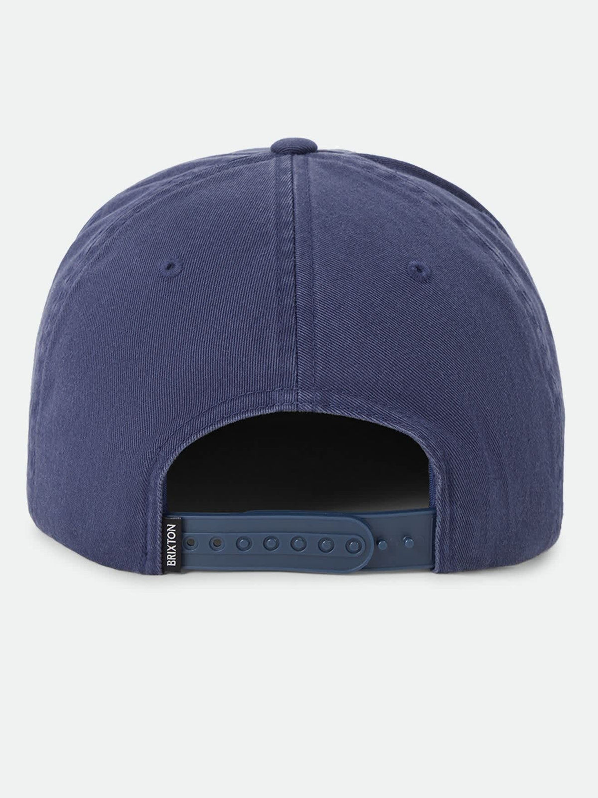 A close-up rear view of a blue snapback cap on a light gray background, showing the fabric crown and adjustable strap.
