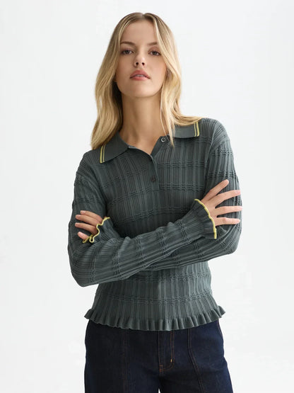 Woman wearing a green polo with yellow trim on a white background