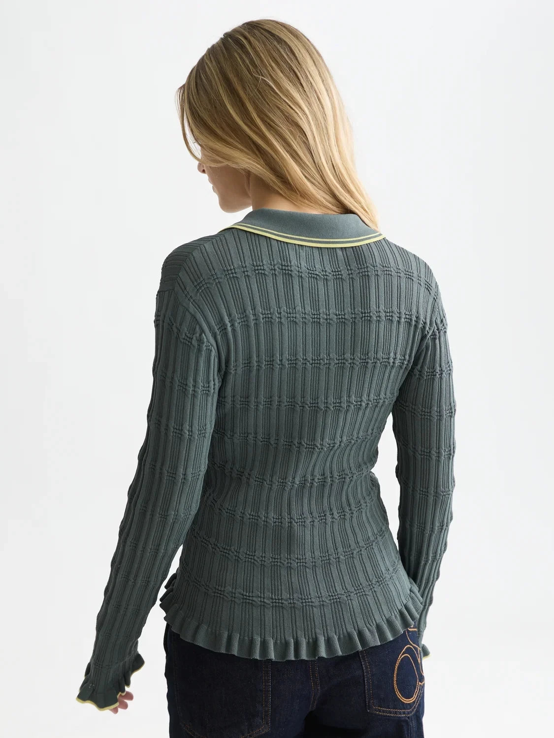 Woman wearing a textured green sweater on a white background