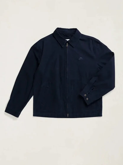 A dark navy blue zip-up jacket with a pointed collar and a small embroidered logo on the left chest, displayed flat against a light beige background.