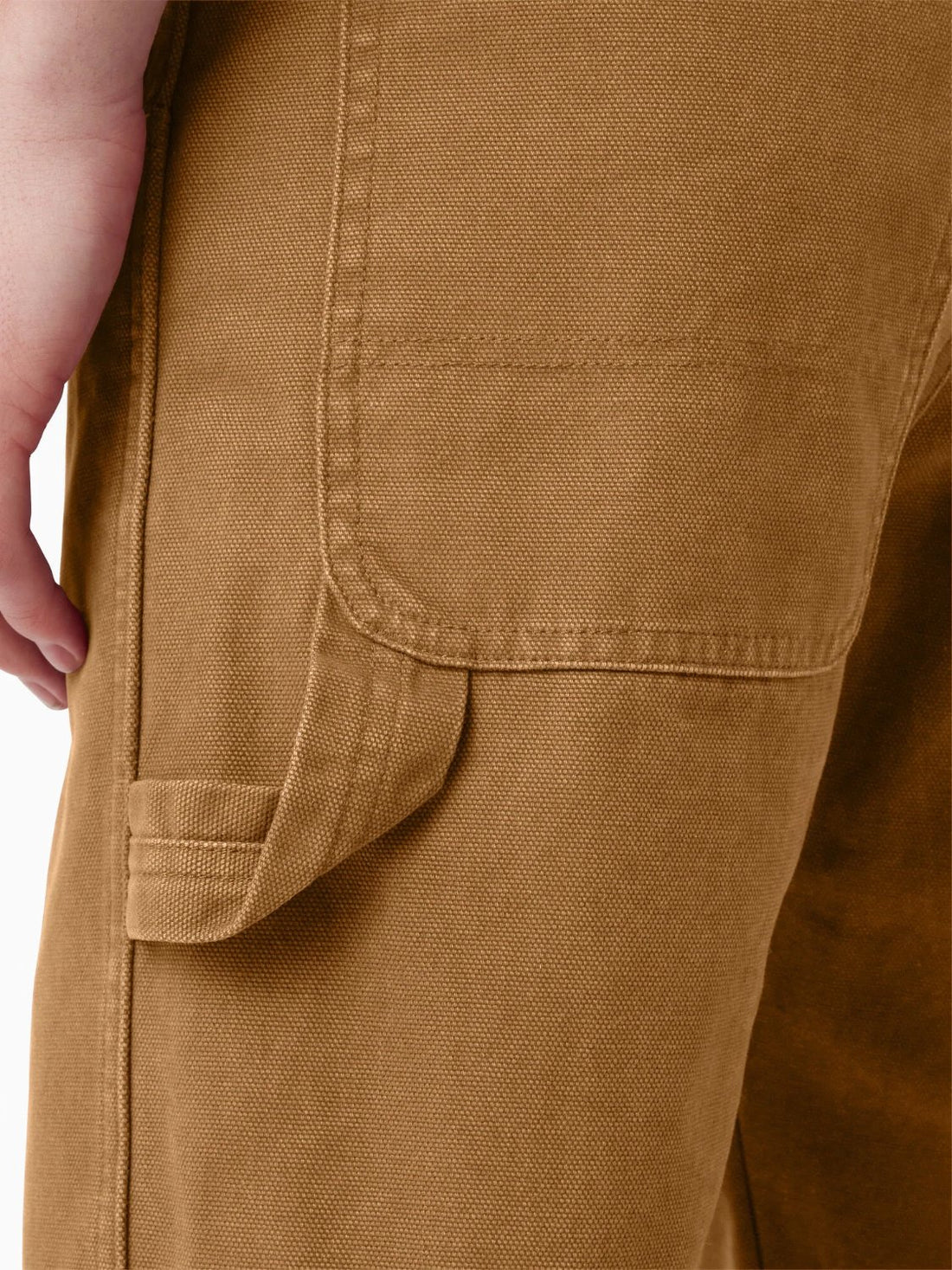 Brown canvas carpenter pants showing a narrow hammer loop beside the back pocket and vertical tool pocket